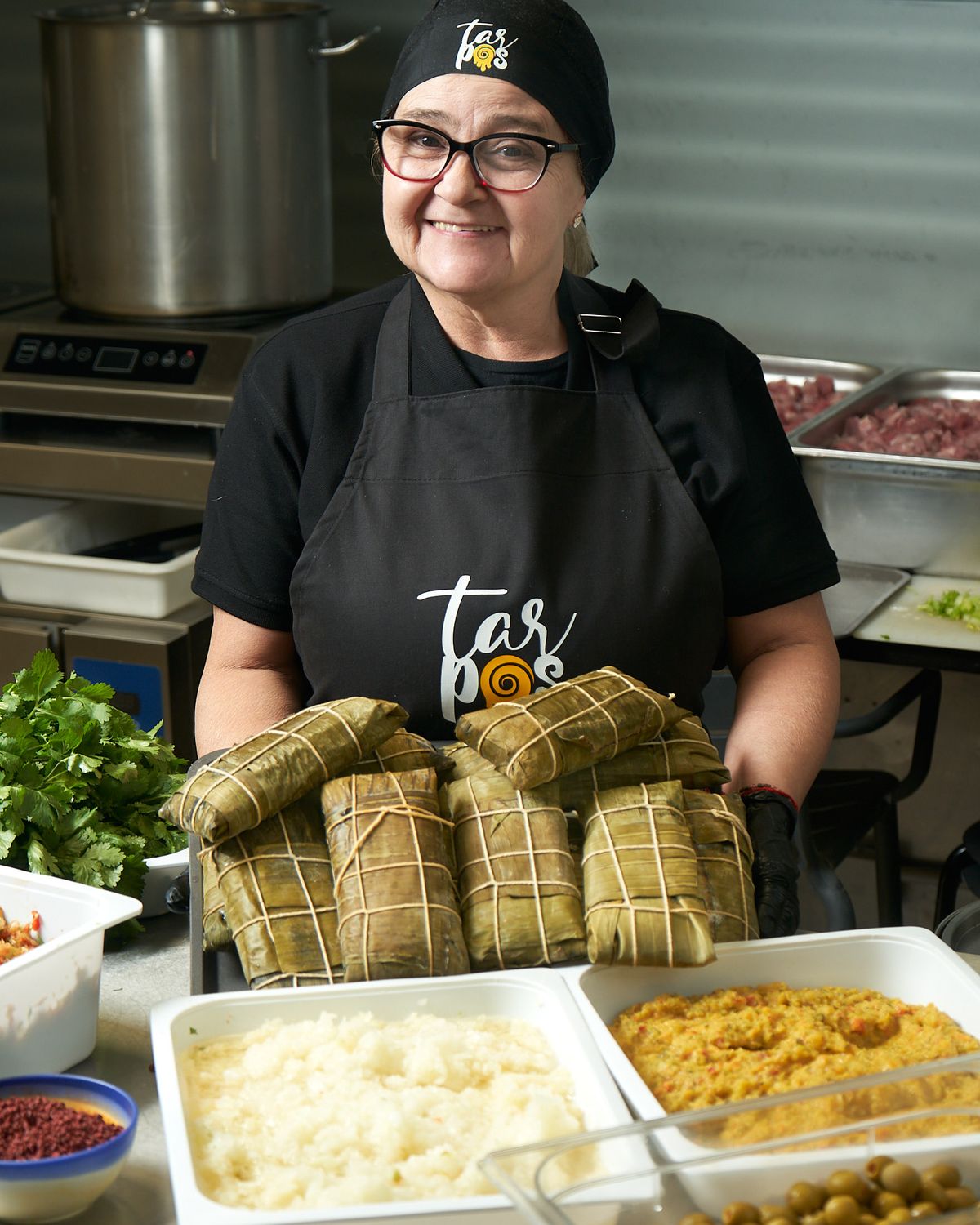 Mary con una bandeja de hallacas en la cocina de TarPos